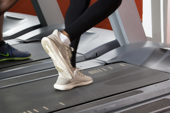A person training on a treadmill, frame focused on their feet.