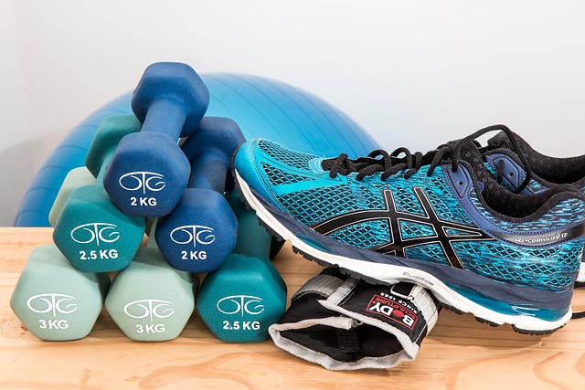 A neat pile of dumbbells and a pair of running shoes.