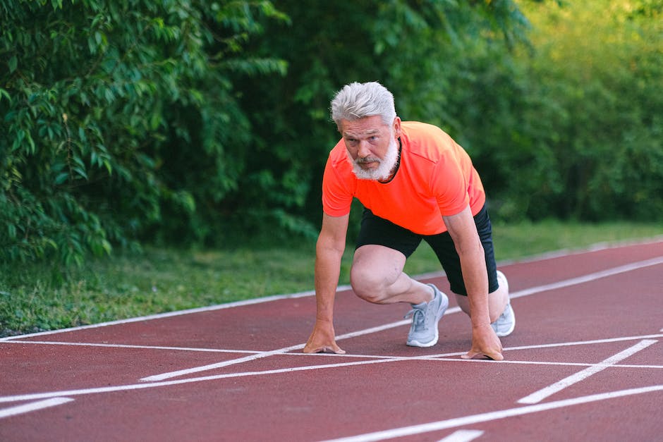 A person on a race track, ready to start running.