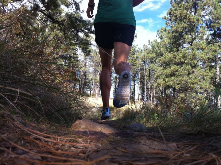 a person running on a track, frame focused on their running shoes